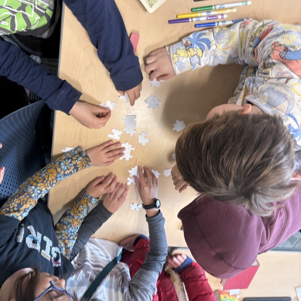 Kids working together on a puzzle during book club